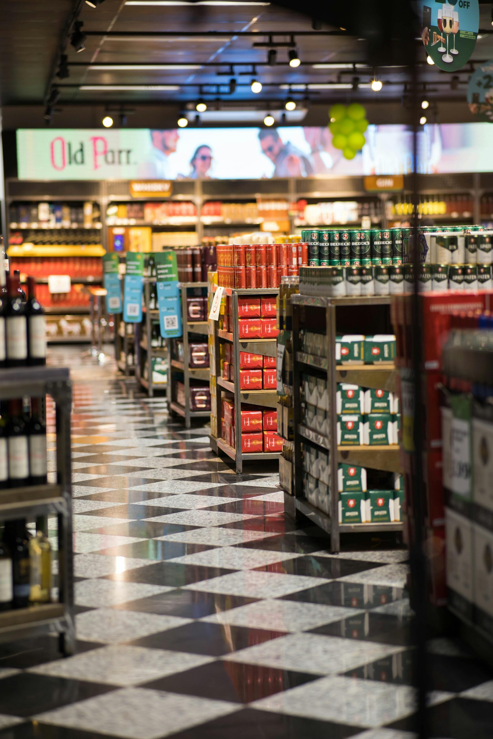 A quiet evening in a grocery store with neatly stacked products and checkered floors.